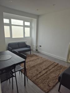 a living room with a couch and a table at One bed flat in UB5 in Northolt
