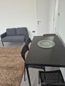 a table and chairs in a living room with a couch at One bed flat in UB5 in Northolt