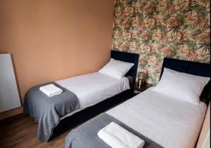 two beds in a hotel room with towels at Domki La Bella 3 in Aleksandria