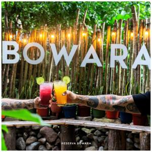 two people with tattoos holding drinks in their hands at RESERVA BOWARA - Ecolodge in Pamplonita +18 photos