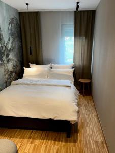 a bedroom with a large bed with white sheets at Green Nights Hotel in Dettelbach +4 photos