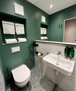 a bathroom with a white toilet and a sink at Green Nights Hotel in Dettelbach