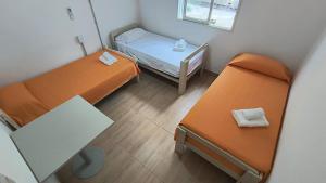 a small room with two beds and a table at Casa Celina in La Falda