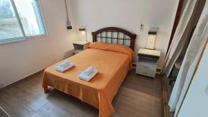 a bedroom with a bed and two towels on a table at Casa Celina in La Falda +2 photos