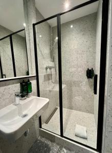 a white bathroom with a sink and a shower at Green Nights Hotel in Dettelbach