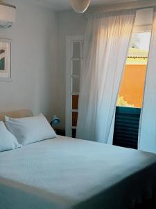 a bedroom with a bed with a window and a bedspread at Condo-Resort Juquehy, 4 quartos, em frente ao mar in São Sebastião