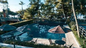 a pool with chairs and umbrellas in front of it at Condo-Resort Juquehy, 4 quartos, em frente ao mar in São Sebastião +25 photos