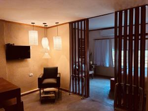 a living room with a chair and a television at Boutique Hotel Casa Teatro in Manaus