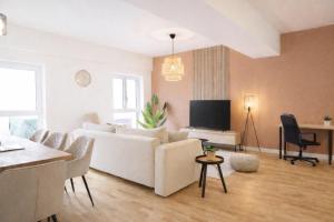 a living room with a white couch and a tv at Whirlpool & Terrasse - Familien & Gruppenfreundlich in Aschaffenburg