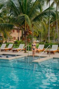 a woman in a bikini sitting in a swimming pool at Hotel Chiniu in Palomino +198 photos