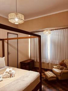 a bedroom with a bed and a chair and a window at Boutique Hotel Casa Teatro in Manaus