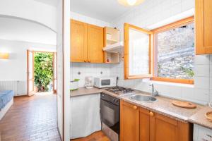 a kitchen with a sink and a stove top oven at Domu de Zita in Poggio