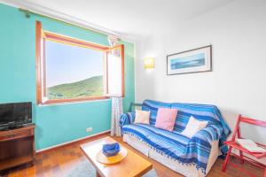 a living room with a couch and a window at Domu de Zita in Poggio +7 photos