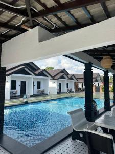 a large swimming pool with a table and chairs at RAZAK GUEST HOUSE in Setiu