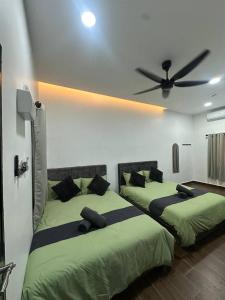 two beds in a bedroom with a ceiling fan at RAZAK GUEST HOUSE in Setiu +37 photos