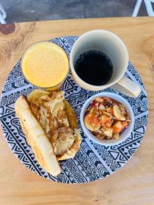 ein Teller mit Essen, einem Hotdog und einer Tasse Kaffee in der Unterkunft Em Casa Hostel in Itacaré