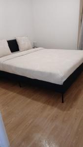 a bed sitting on a wooden floor in a room at Chic 2 chambres appartement proche de Paris in Vitry-sur-Seine