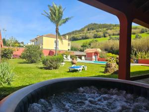 a garden with a fire pit in the yard at A Casa do Comandante - Piscina e Jardim in Lagoa