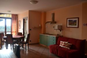 a living room with a red couch and a kitchen at Alisea Eco Residence in Pocapaglia