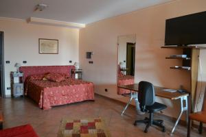 a bedroom with a bed and a desk and a mirror at Alisea Eco Residence in Pocapaglia