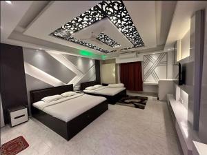 a bedroom with two beds and a mirror at Rainbow Guest House in Sylhet