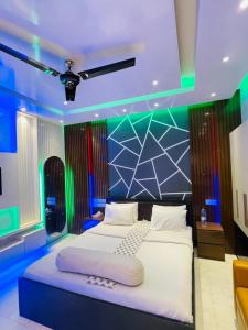 a bedroom with a large bed with blue and green lights at Rainbow Guest House in Sylhet