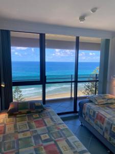 a bedroom with two beds and a view of the ocean at High Level with Ocean Views Everywhere in Buddina +21 photos