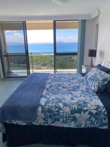 a bedroom with a bed and a view of the ocean at High Level with Ocean Views Everywhere in Buddina