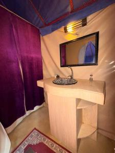 a bathroom with a sink and a mirror in a tent at Elite Sahara Desert Camp in Merzouga +40 photos