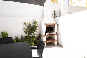 a patio with a pizza oven on the side of a building at Baleal Holiday House in Baleal
