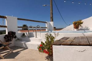 a patio with stairs and a table and flowers at Encanto do frade in Carrapatelo