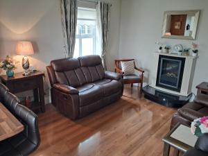 a living room with a couch and a chair at Warm Spacious Three Bed Chalet in Galway