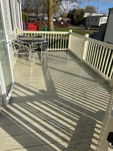 a deck with a table and chairs on a house at Oakley caravan rental in Skegness