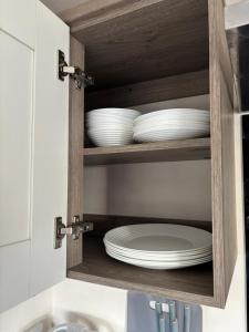 a cupboard with plates and dishes in it at Oakley caravan rental in Skegness +15 photos