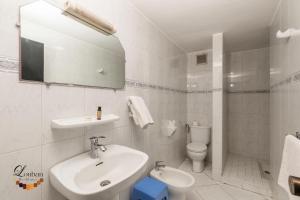 a white bathroom with a sink and a toilet at Hôtel Résidence Louban in Agadir +23 photos