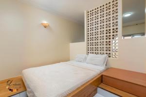 a bedroom with a white bed and a wooden desk at Hôtel Résidence Louban in Agadir