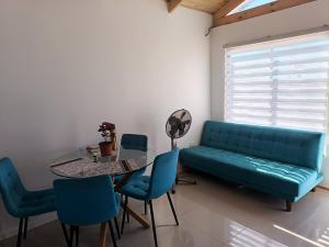 a living room with a couch and a table and chairs at Cabaña Litueche in Los Manantiales