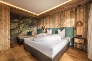 a bedroom with a large white bed with wooden walls at Haus Barbara in Alpbach