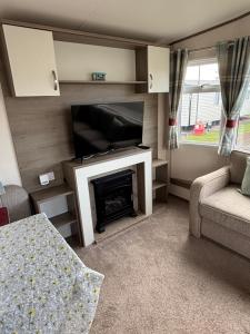 a living room with a television and a fireplace at Oakley caravan rental in Skegness
