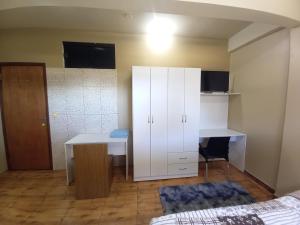 a bedroom with a desk and a white cabinet at Colman Apart Central in Ciudad del Este