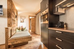 a kitchen with a bench in the middle of a room at Haus Barbara in Alpbach +28 photos