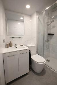 a white bathroom with a toilet and a shower at Suites Prieto Fuengirola Centro in Fuengirola