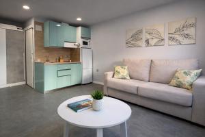 a living room with a couch and a table at Suites Prieto Fuengirola Centro in Fuengirola +7 photos