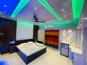 a bedroom with a bed with green lights on it at Rainbow Guest House in Sylhet