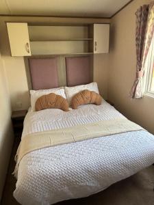 a bedroom with a large bed with two pillows at Oakley caravan rental in Skegness