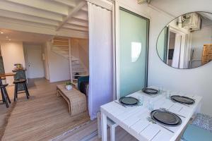 ein Esszimmer mit einem weißen Tisch und einem Spiegel in der Unterkunft Mare Gaillard in Le Gosier