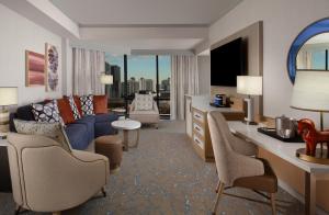 a living room with a blue couch and a tv at Hilton Anatole in Dallas