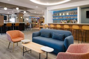 a lobby with a blue couch and a bar at EVEN Hotel Rockville - Washington, DC Area by IHG in Rockville