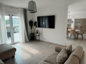 a living room with a couch and a tv on a wall at Luxury Apartments Marz in Schwanau