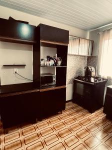 a kitchen with black cabinets and a microwave at La casita in Foz do Iguaçu